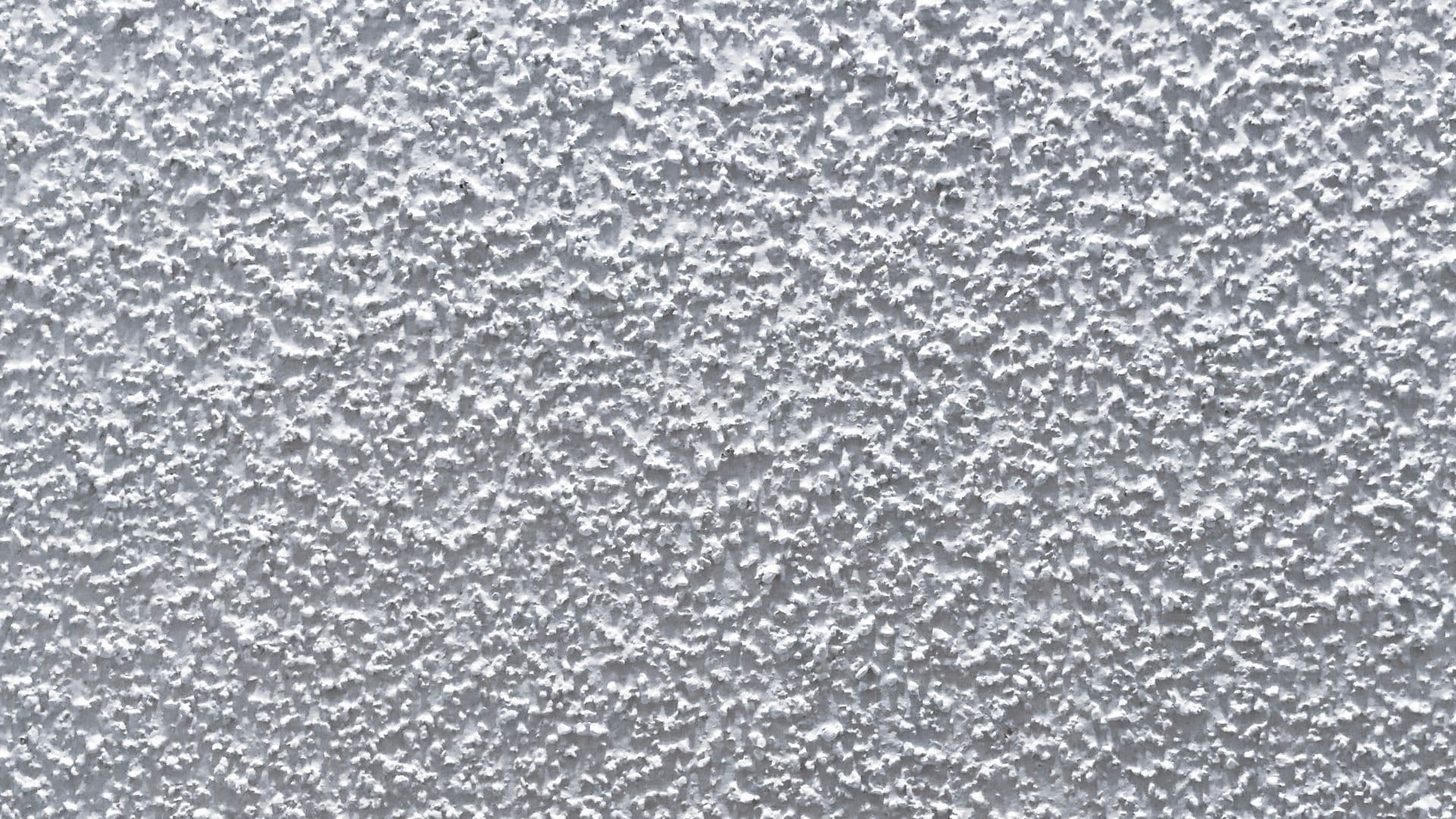 Close view of white popcorn ceiling texture before removal