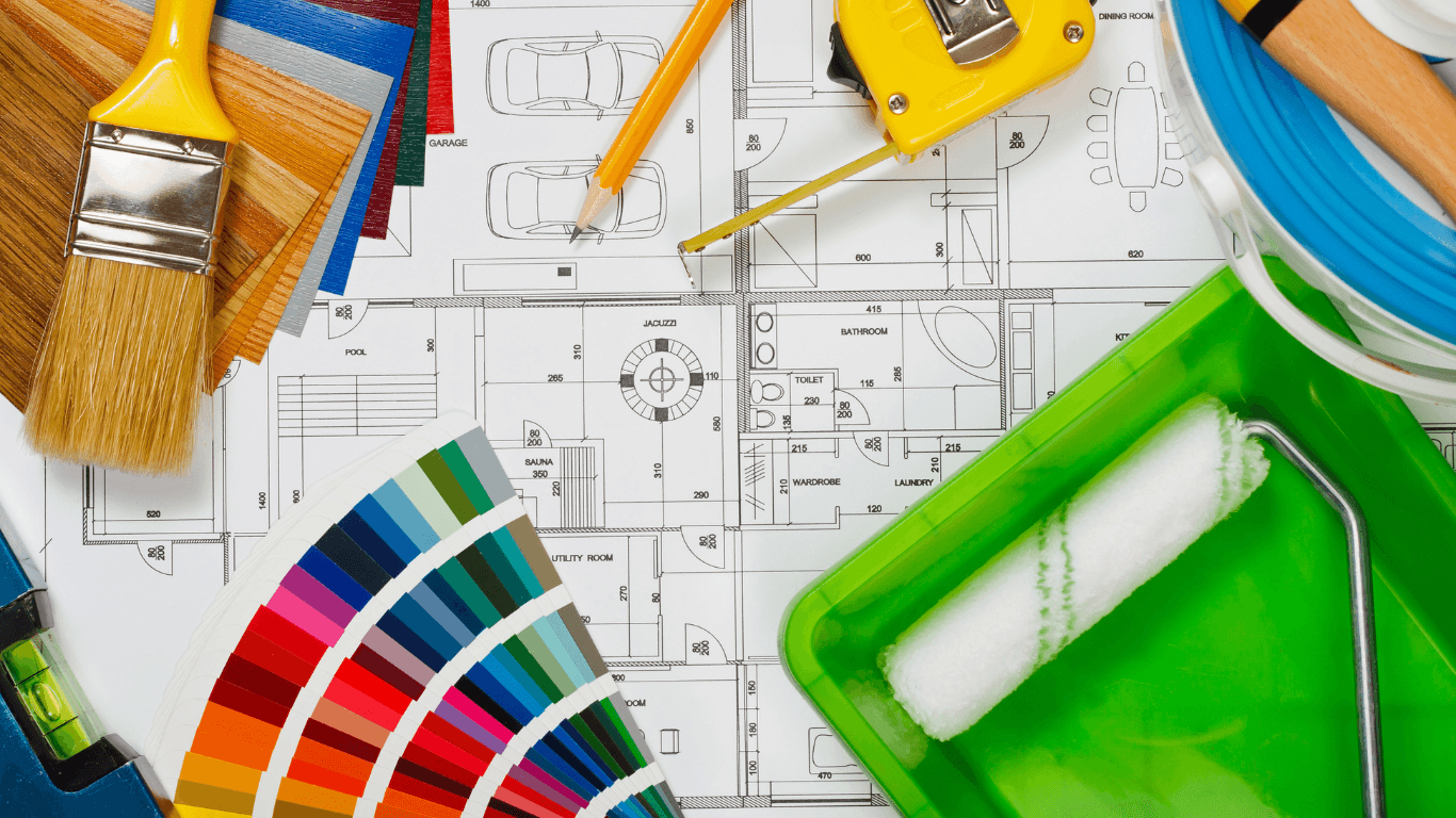 Paint tools, color samples, and a tape measure on architectural plans