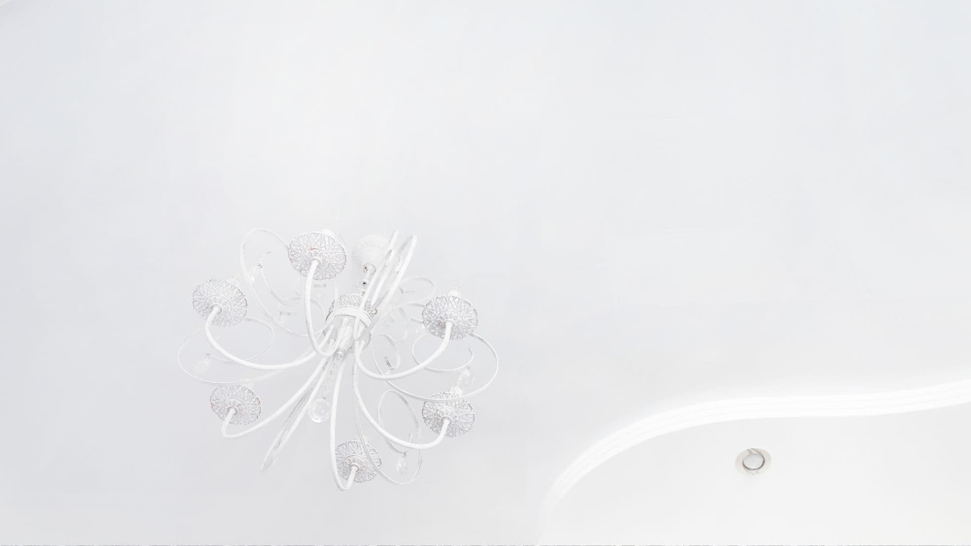 Smooth white interior ceiling with a chandelier after a clean paint finish